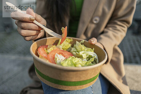 Junge Frau isst eine Schüssel Salat