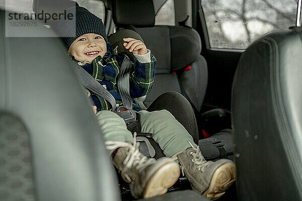 Happy cute boy in car safety seat