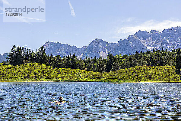 Germany  Bavaria  man swimming in Wildensee lake