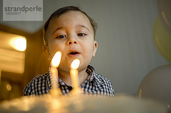 Netter Junge bläst Kerzen und feiert zu Hause seinen Geburtstag