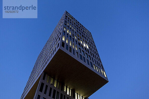 Deutschland  Bayern  München  Tiefansicht eines modernen Bürogebäudes in der Abenddämmerung