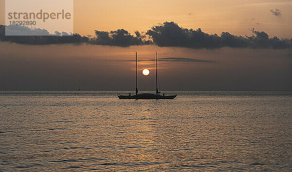 Spanien  Balearen  Sonnenuntergang über einem Segelboot  das auf dem Meer schwimmt
