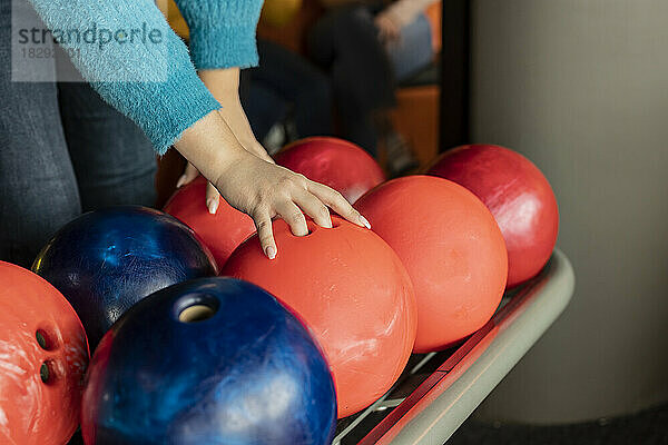 Hand of woman lifting bowling ball
