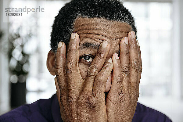Mature man covering face with hands
