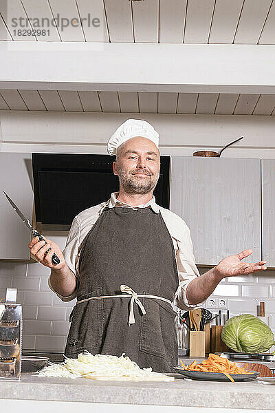 Portrait of man wearing chef clothing in kitchen at home