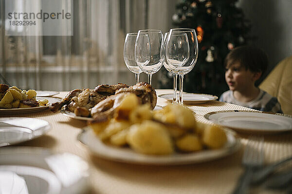 Junge mit Essen auf dem Esstisch zu Hause