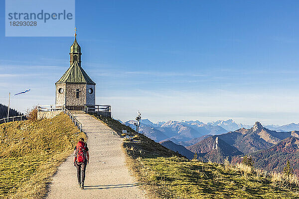 Deutschland  Bayern  Wanderin auf dem Weg zur Heilig-Kreuz-Kapelle  die auf dem Gipfel des Wallbergs steht
