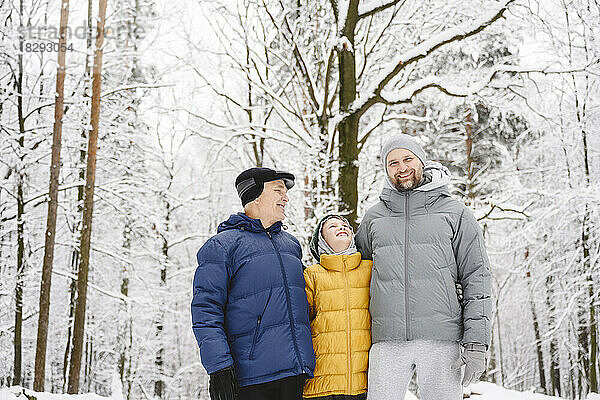 Glücklicher Junge mit Vater und Großvater  der den Winter im Park genießt