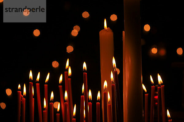 Candles burning against dark background