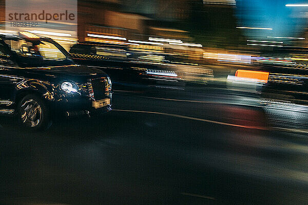 UK  England  London  Blurred motion of driving taxi and surrounding traffic at night