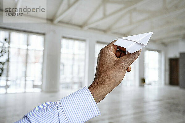 Hand of businessman holding paper airplane