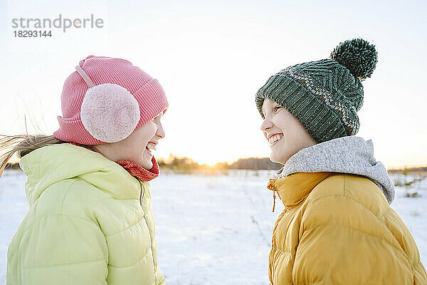 Fröhliches Mädchen genießt den Winter mit seinem Bruder