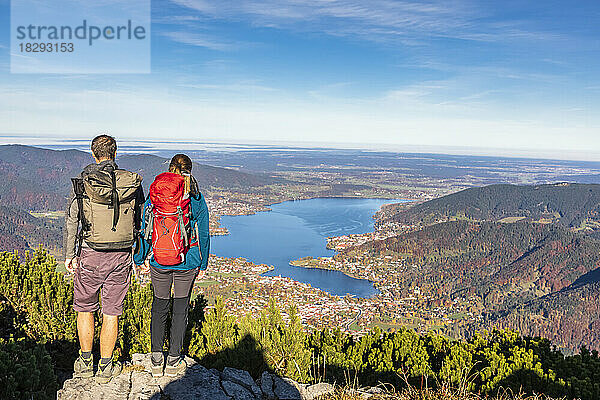 Deutschland  Bayern  Rottach-Egern  Wanderpaar genießt vom Gipfel des Wallbergs den Blick auf den Tegernsee und die umliegenden Städte