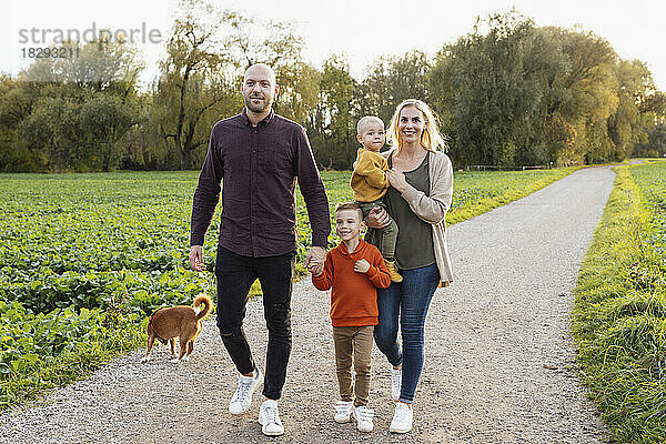 Glückliche Familie geht auf Fußweg in der Natur spazieren
