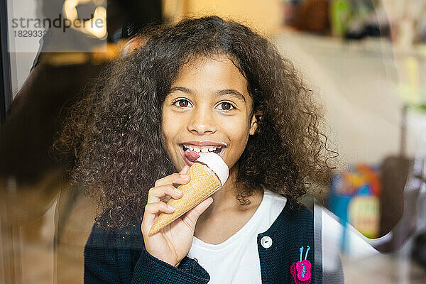 Smiling girl eating ice cream at home