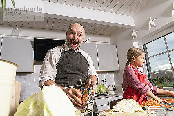 Glücklicher Vater und Tochter bereiten zu Hause in der Küche gesunde Mahlzeiten zu