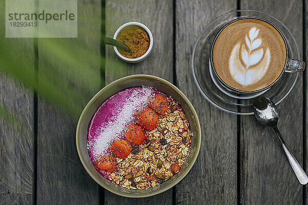 Cup of coffee and bowl of pitaya muesli