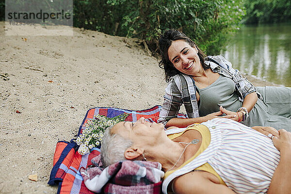 Glückliche Frauen entspannen sich am See im Park