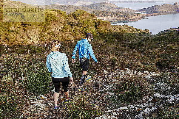 Trailrunner-Paar bewegt sich den Berg hinunter