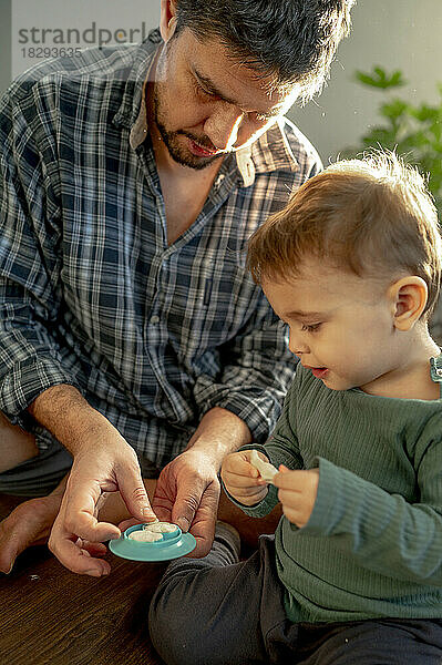 Vater und Sohn spielen zu Hause mit Ton