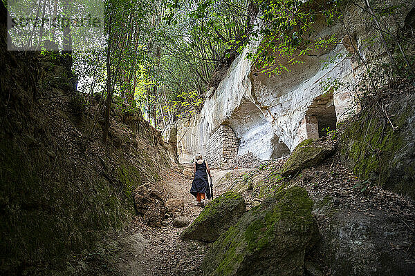 Aktive ältere Frau  die inmitten von Felsen spaziert