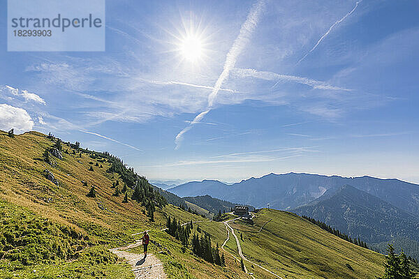 Germany  Bavaria  Sun shining over female hiker on way to Rotwandhaus