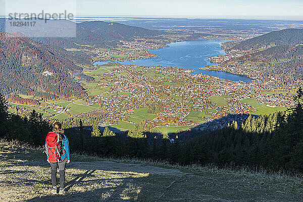 Deutschland  Bayern  Rottach-Egern  Wanderin genießt vom Gipfel des Wallbergs aus den Blick auf den Tegernsee und die umliegenden Städte