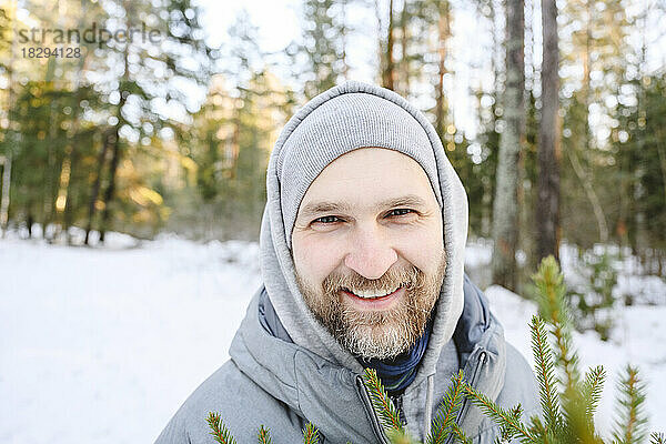 Glücklicher Mann mit Bart im Winterwald