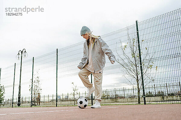 Teenager-Mädchen spielt mit Fußball