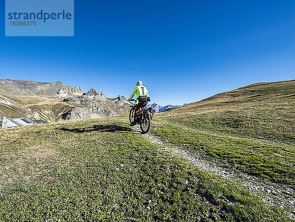 Mann fährt Mountainbike auf Trail unter blauem Himmel  Nationalpark Vanoise  Frankreich
