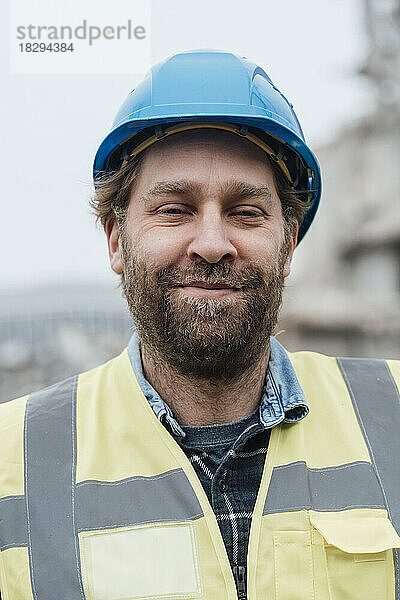 Lächelnder Bauarbeiter mit Schutzhelm