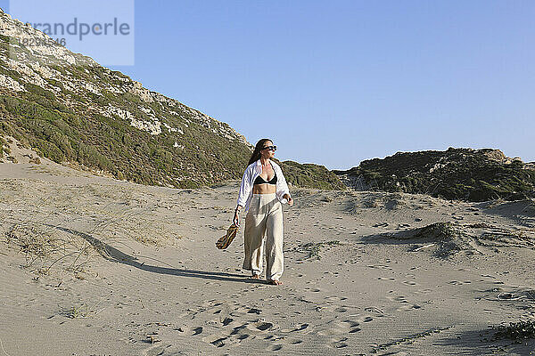 Junge Frau spaziert an einem sonnigen Tag am Strand  Patara  Türkei