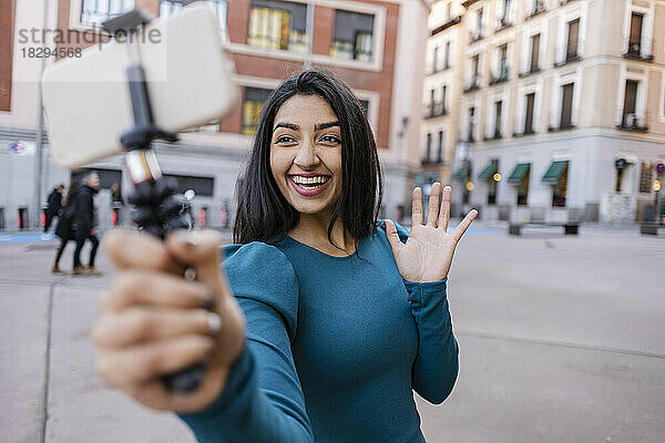 Glückliche Frau  die in der Stadt ein Selfie über ihr Smartphone macht