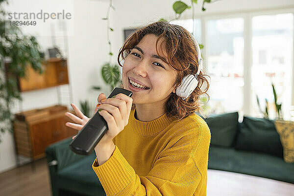 Glückliche junge Frau  die zu Hause singt