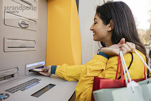 Frau hebt Geld vom Geldautomaten ab