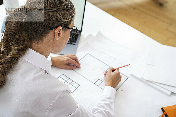 Ingenieur arbeitet an Blaupause im Büro