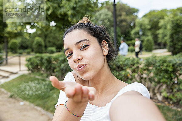 Frau gestikuliert und macht Selfie im Park