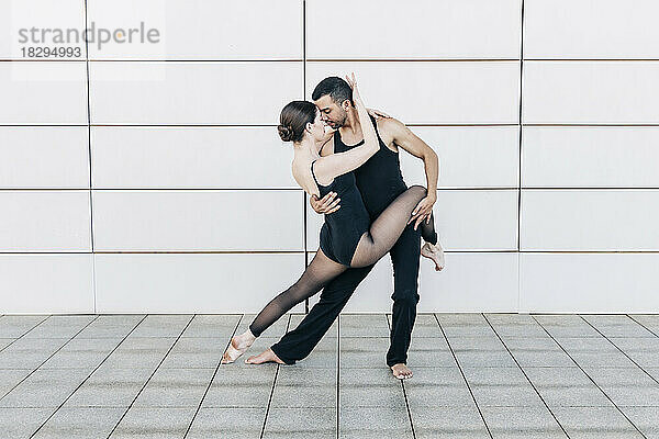 Paar führt Balletttanz vor der Wand auf
