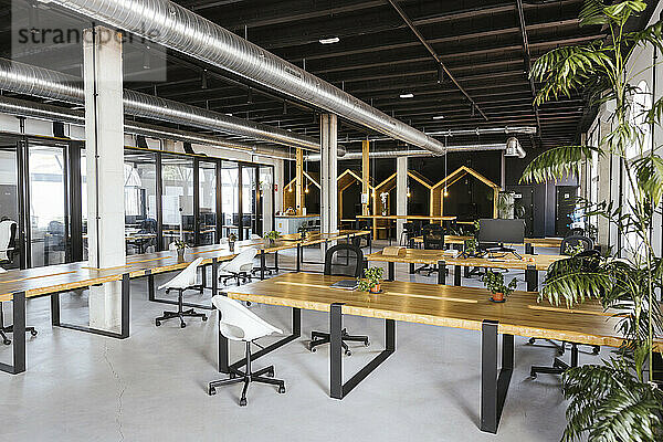 Innenraum eines leeren modernen Coworking-Büros mit Schreibtischen und Stühlen