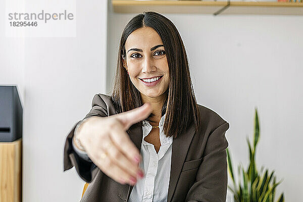 Smiling recruiter making handshake gesture in office