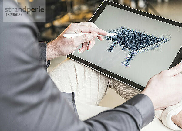Junger Geschäftsmann zeichnet im Büro Solarpanel auf Tablet-PC