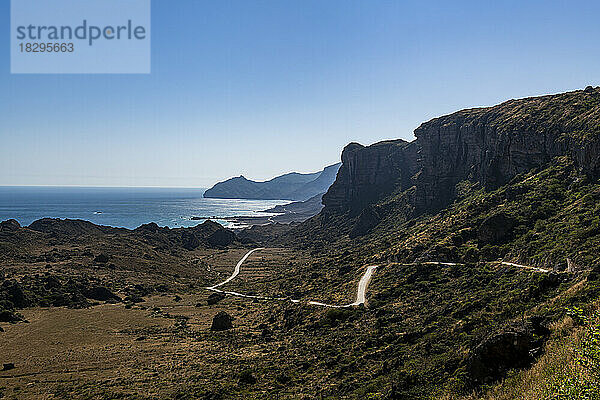 Oman  Dhofar  Salalah  kurvenreiche Straße mit Küstenklippen im Hintergrund
