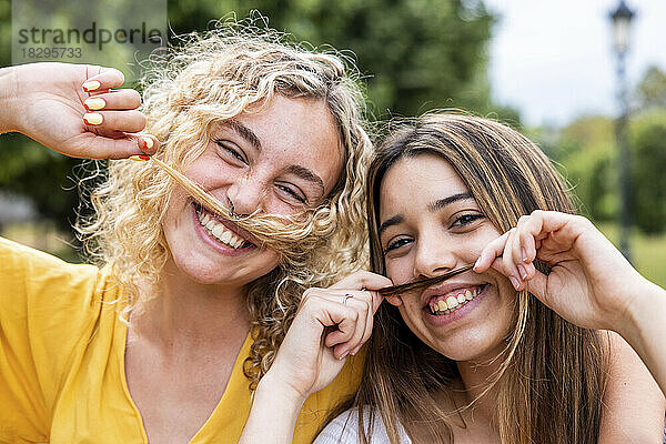 Fröhliche Freunde mit Schnurrbart im Park