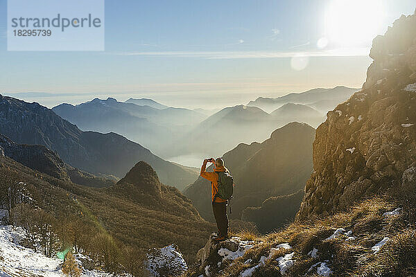 Wanderer fotografiert mit Smartphone auf dem Berg