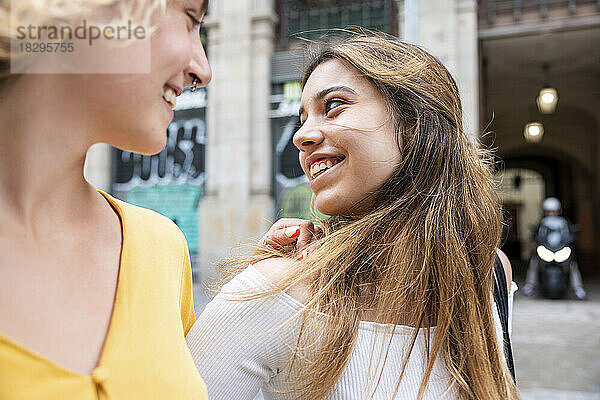 Lächelnde junge Frau verbringt ihre Freizeit mit einer Freundin