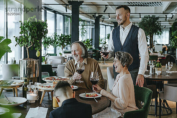 Glückliche Familie genießt das Essen am Esstisch im Café