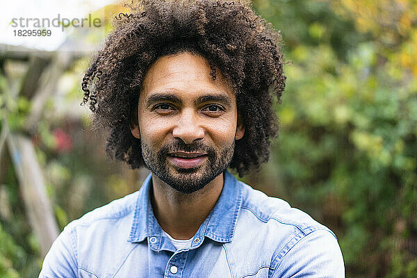 Lächelnder Mann mit Afro-Frisur und Bart