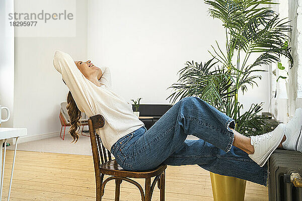 Glückliche Geschäftsfrau entspannt sich auf einem Stuhl im Büro