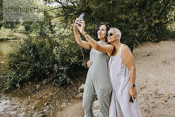 Lächelnde Frauen machen Selfie mit Smartphone im Park