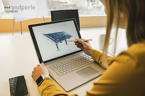 Junge Geschäftsfrau zeichnet mit digitalisiertem Stift Solarpanel auf Laptop